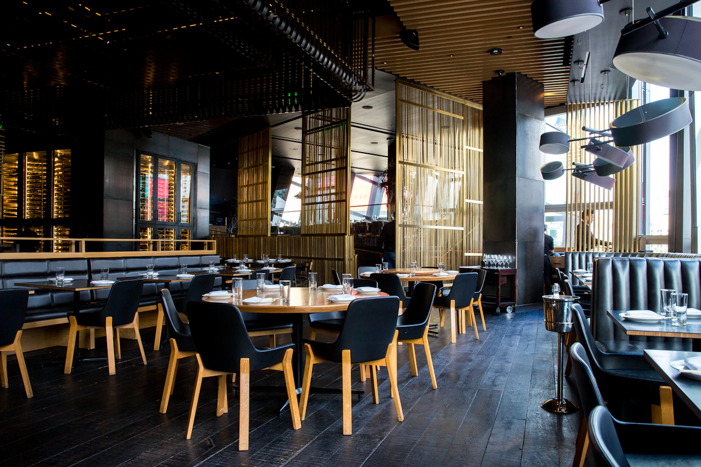 Warm restaurant dining room with wooden tables and pendant lighting